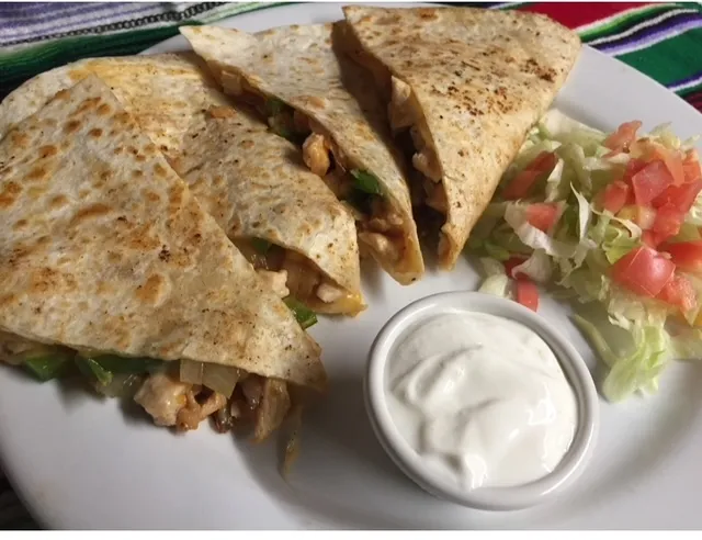 Flour tortilla quesadilla with sour cream and pico de gallo