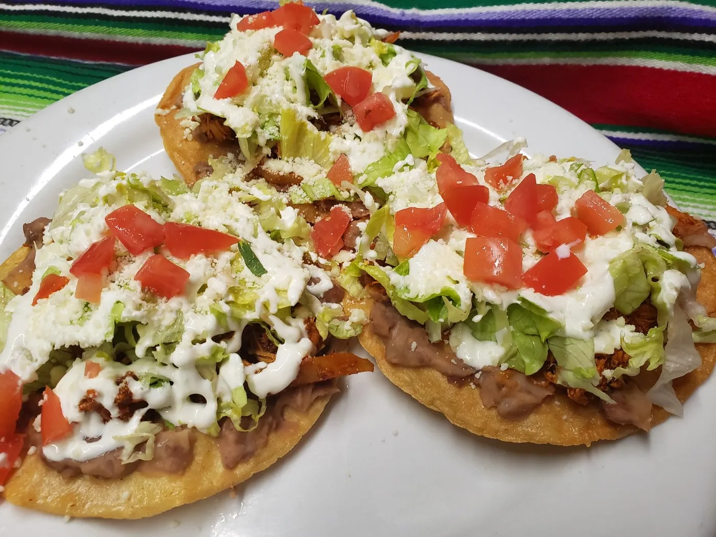 Tinga tostadas with lettuce, tomato and cream